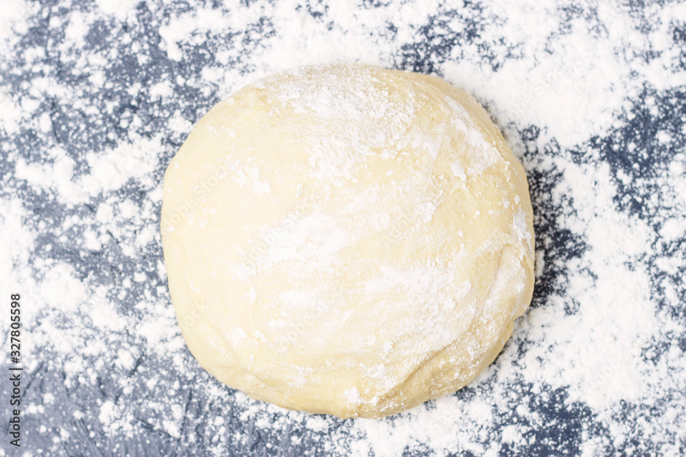 Raw round dough with flour top view, copy space, gray background Raw round dough with flour top view, copy space, gray background