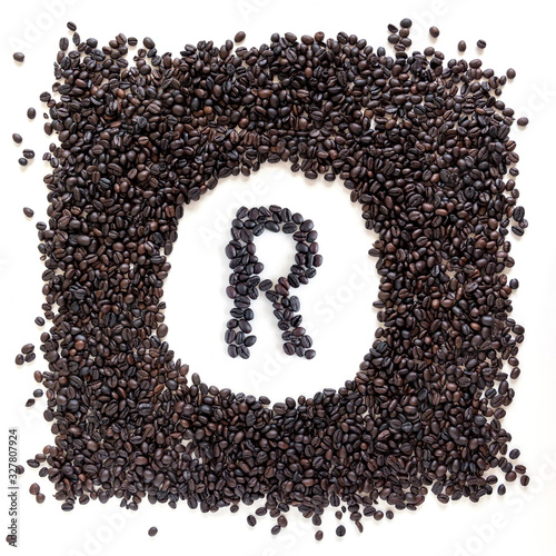 Letter R made out of aromatic coffee beans, top view, isolated on white background. Letter from word Aroma.