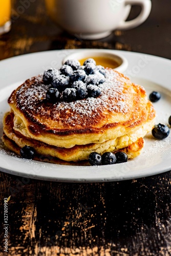 Pancakes. Homemade blueberry buttermilk pancakes. Classic Traditional American breakfast or brunch favorite. Topped with fresh berries, sugar and maple syrup. 