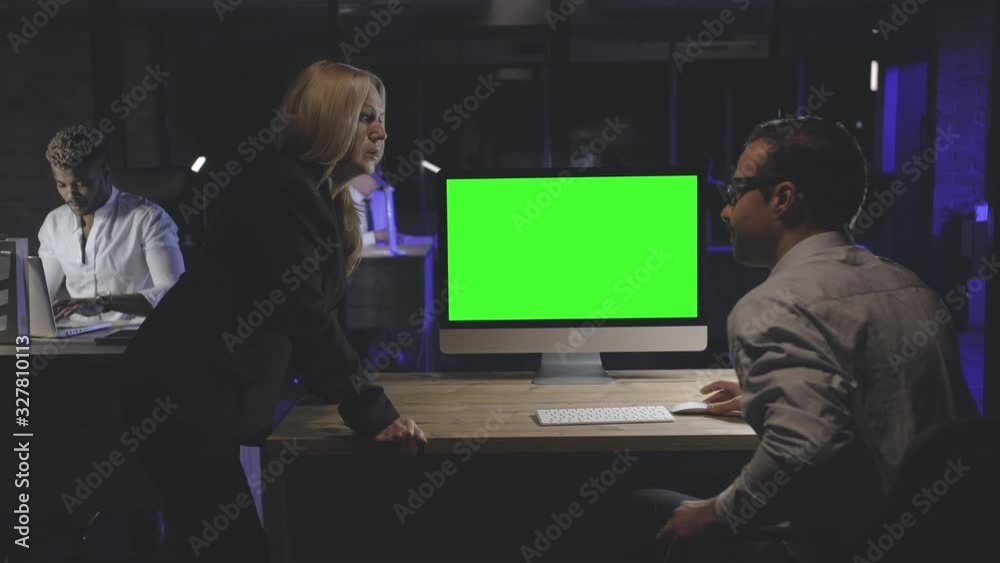 Coworkers discussing business plan in night office. Coworkers discussing business plan in night office.