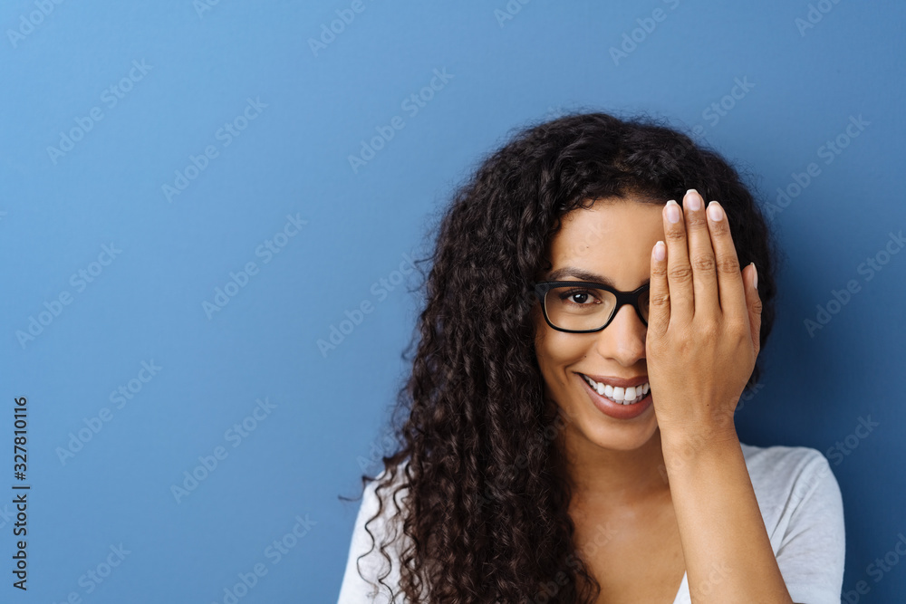 Happy smiling young woman covering her eye - obrazy, fototapety, plakaty 