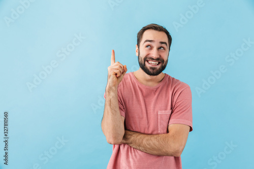 Pleased man posing isolated over blue wall background.