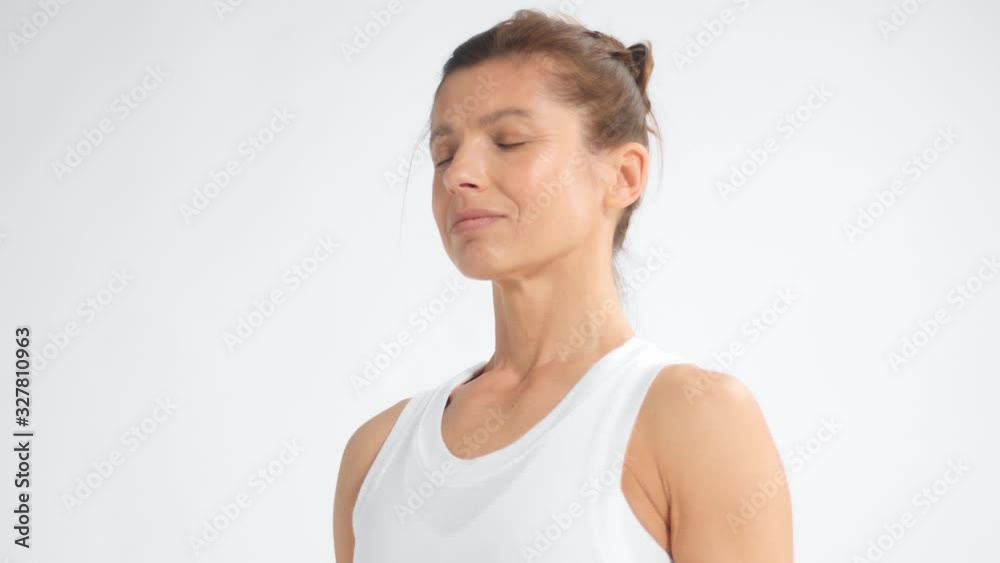 Senior woman in white space practice yoga closeup dolly portrait with eyes closed Senior woman in white space practice yoga closeup dolly portrait with eyes closed