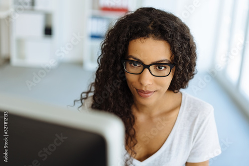 Beautiful black woman in glasses works at computer