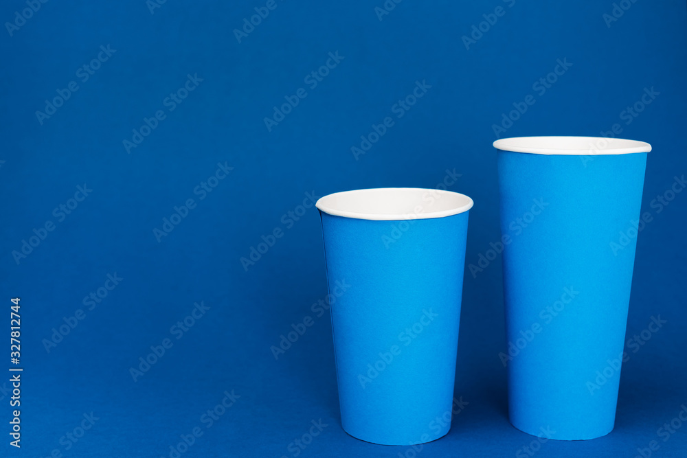 paper cups with soda on blue background with copy space paper cups with soda on blue background with copy space