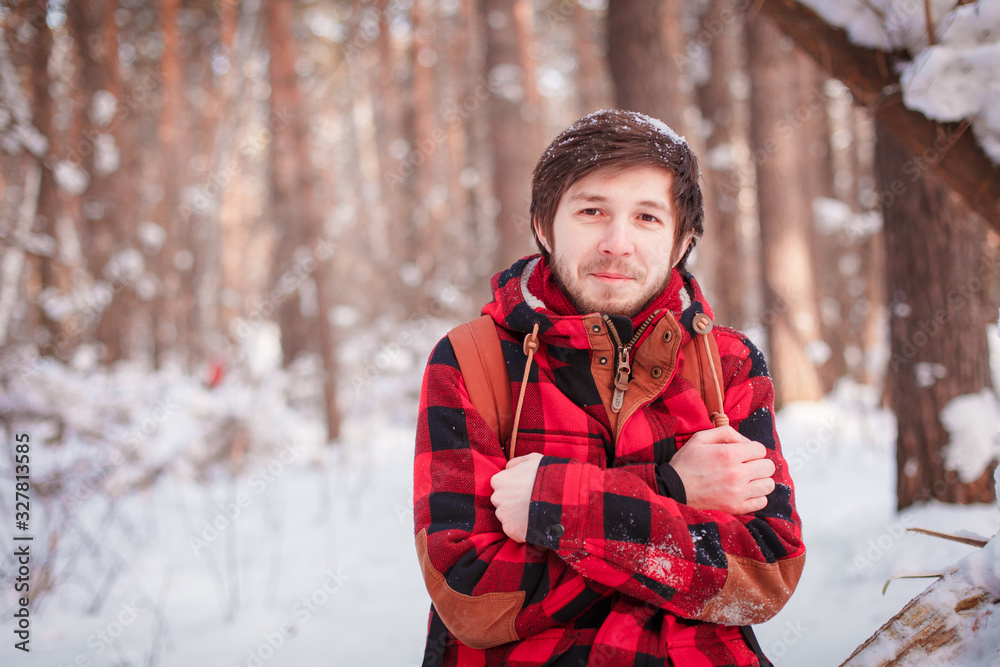 Photo of cheerful male resting, looks directly into camera, sits in snow pine winter forest, smiles happily, enjoys communication, admires landscapes Photo of cheerful male resting, looks directly into camera, sits in snow pine winter forest, smiles happily, enjoys communication, admires landscapes