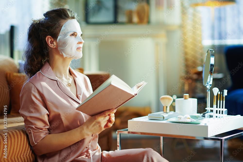 young woman with facial mask holding book