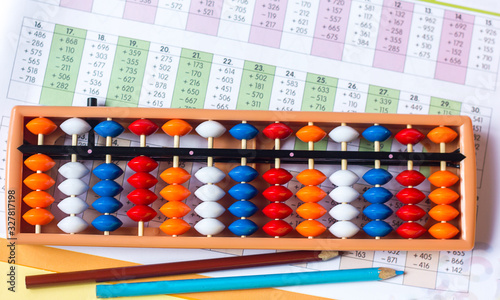 Mental arithmetic and development concept  abacus and mathematical examples on a yellow background