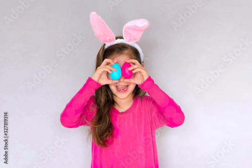 Happy Easter! Little girl having fun to paint Easter eggs.