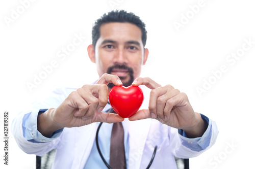 Adult Doctor wearing a doctor' gown with a stethoscope hanging on the neck sitting and holding the red heart, isolated on white background. © JuYochi