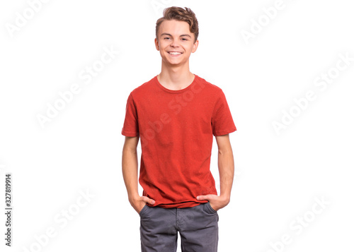 T-shirt design concept. Teen boy in blank red t-shirt, isolated on white background. Mock up template for print. Happy child with hands in pockets, looking at camera, front view. photo