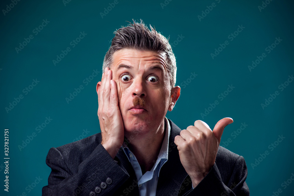 A portrait of surprised man with mustache pointing finger. People and emotions concept A portrait of surprised man with mustache pointing finger. People and emotions concept