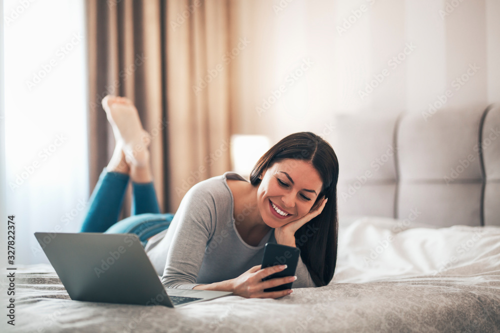 Girl lying on the bed and using phone.