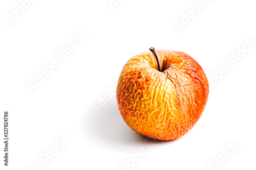 An old shrivelled apple with lots of wrinkles on a white background. Isolated. photo