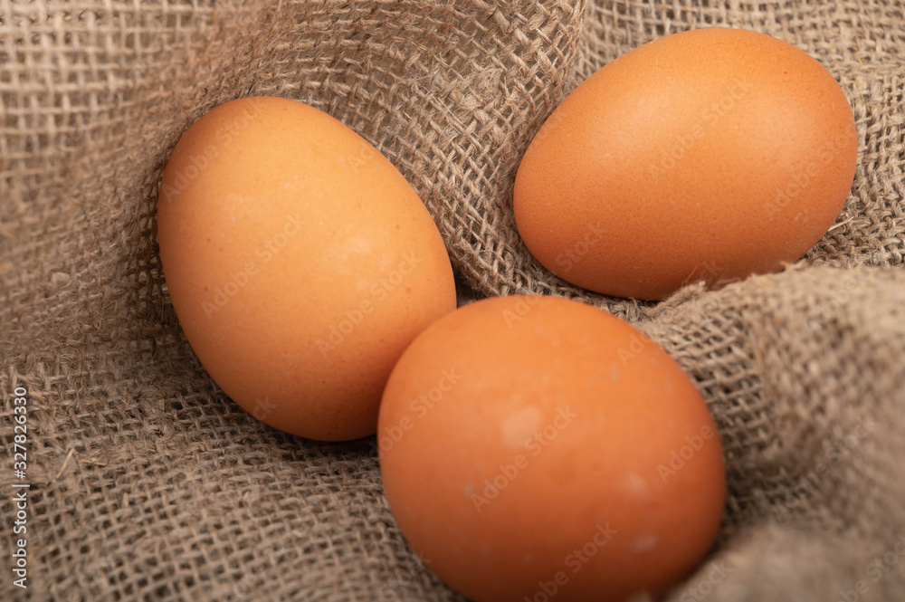 Chicken eggs on a background of rough homespun fabric. Close up. Chicken eggs on a background of rough homespun fabric. Close up.