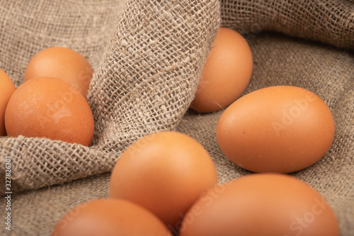 Chicken eggs against a rough homespun fabric. Homemade preparations, Rustic treats. Close up.