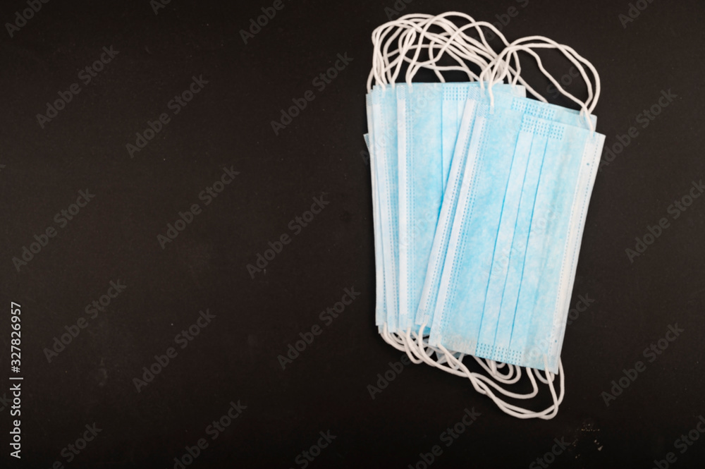 Disposable medical masks on a black background. Individual protection against infectious diseases. Close up. Disposable medical masks on a black background. Individual protection against infectious diseases. Close up.