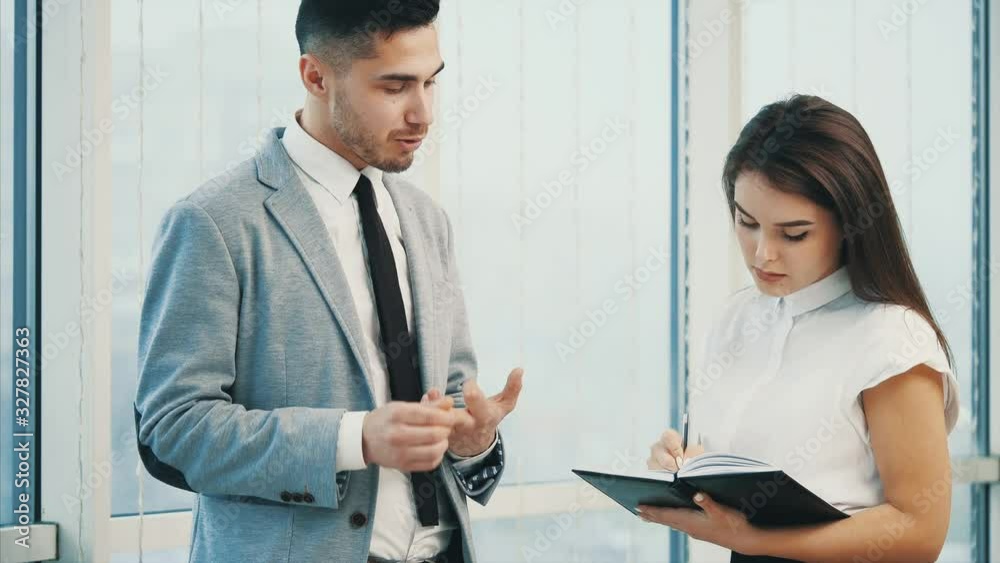 Confident business man is giving directions to his coworker. Blurred white panoramic background. Close up. 4K. Confident business man is giving directions to his coworker. Blurred white panoramic background. Close up. 4K.