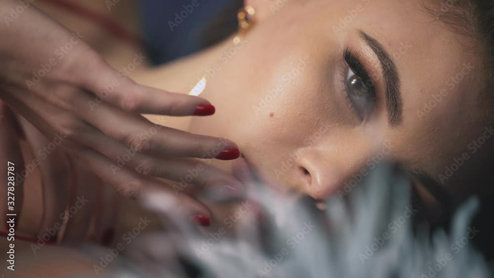 Blur effect portrait closeup woman lying touch face hand makeup eyes with fluffy long eyelashes iris pure skin passion sensual lips romantic female brunette hair style date cosmetic beauty product. Blur effect portrait closeup woman lying touch face hand makeup eyes with fluffy long eyelashes iris pure skin passion sensual lips romantic female brunette hair style date cosmetic beauty product.