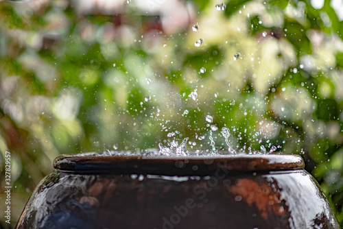 Harvesting downpour rainwater from the roof in the traditional earthen jar, Thailand, Asia. photo