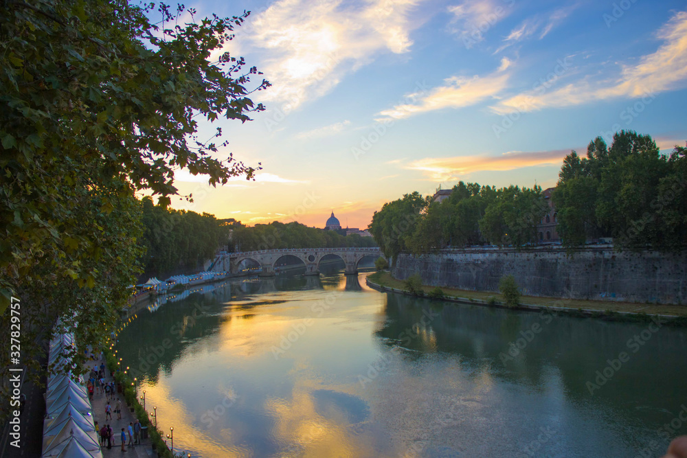 Obraz premium The River Tiber flowing peacefully through Rome at sunset during summer