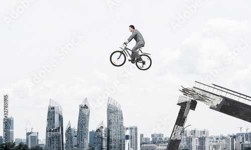 Businessman on bike jumping from broken bridge © adam121