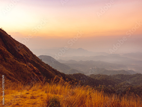 beautiful nature of the hills with golden grass and mountain range in the morning in Tak, Thailand.
