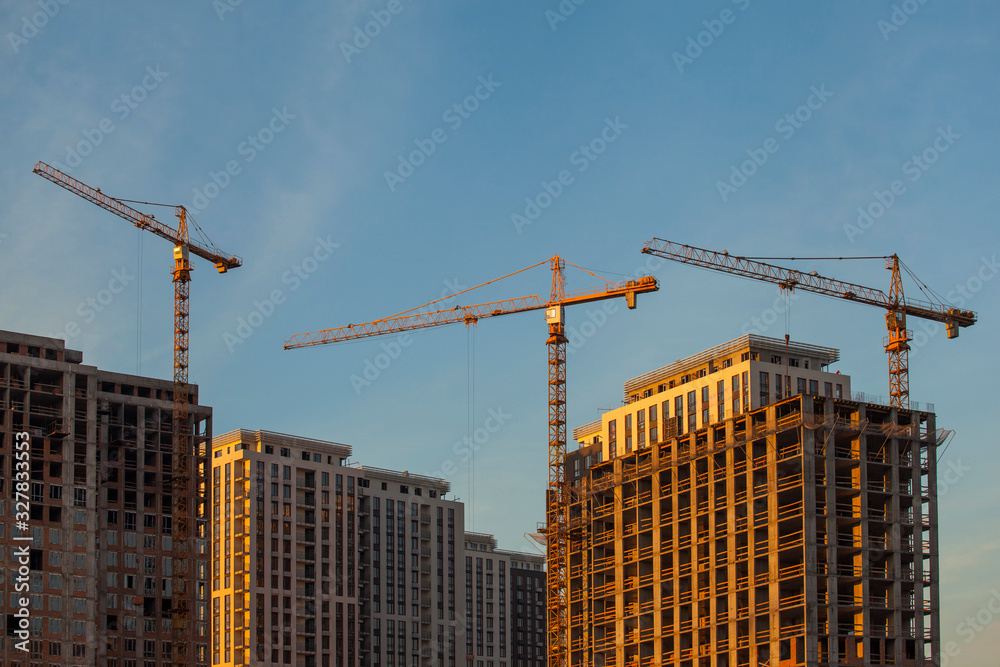 Construction site with cranes against the blue sky Construction site with cranes against the blue sky