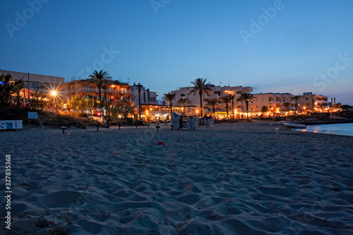 The tourist resort of Es Pujols in the lively and colorful summer evening, seen from the beach.