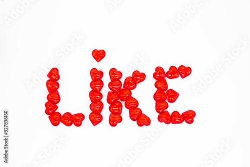 The word "like" is laid out with red glass hearts on a white background Concept of social networks, approval, support