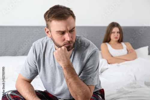 Unhappy couple with relationship problems after quarrel in bedroom