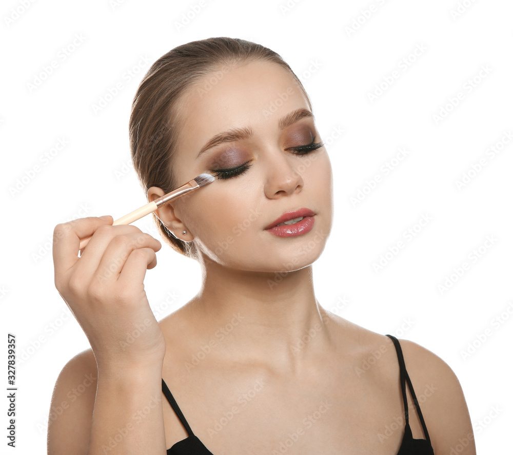 Beautiful woman applying makeup with brush on white background Beautiful woman applying makeup with brush on white background