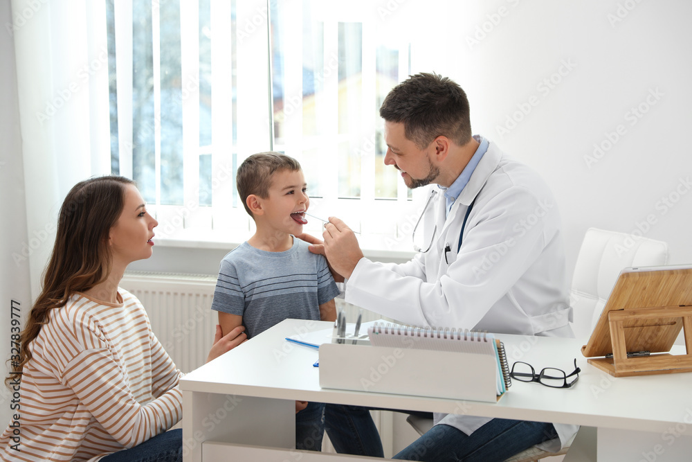 Mother and son visiting pediatrician. Doctor examining little patient's throat in hospital Mother and son visiting pediatrician. Doctor examining little patient's throat in hospital