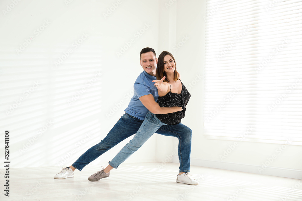 Happy young couple dancing in empty studio