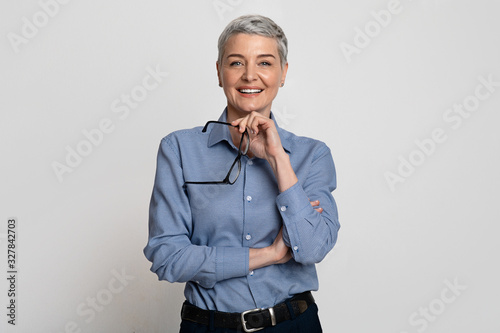Portrait Of Beautiful Mature Businesswoman Holding Glasses And Smiling At Camera