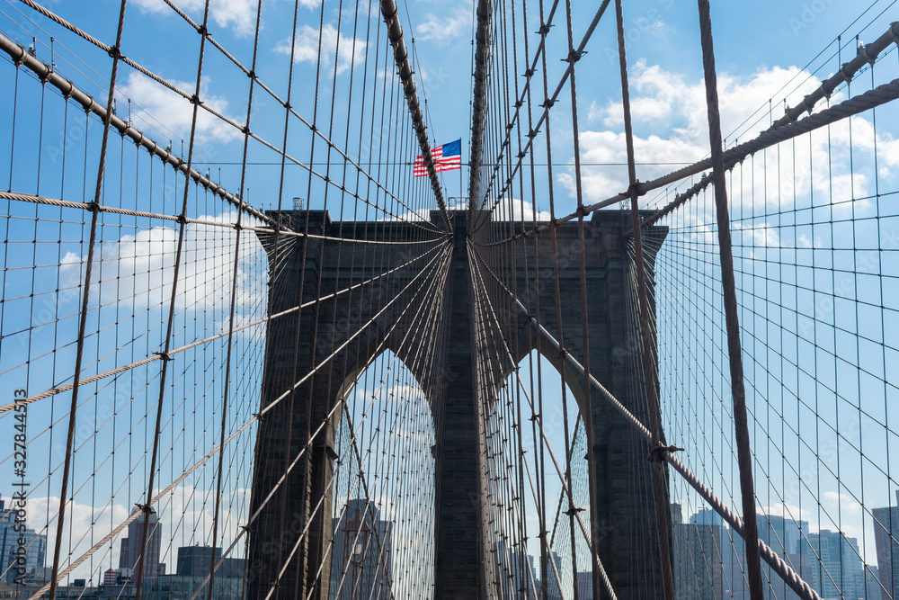 Naklejka premium Arches on the Brooklyn Bridge with an American Flag in New York City