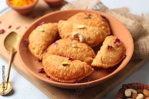 Popular Holi Snack known as Karanji or Gujia is Served on earthen platter. (Holi Concept)