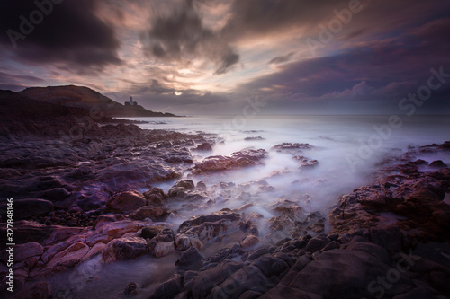 Daybreak over Bracelet Bay with a long exposure over the rock pools on the Gower peninsula in Swansea, South Wales, UK