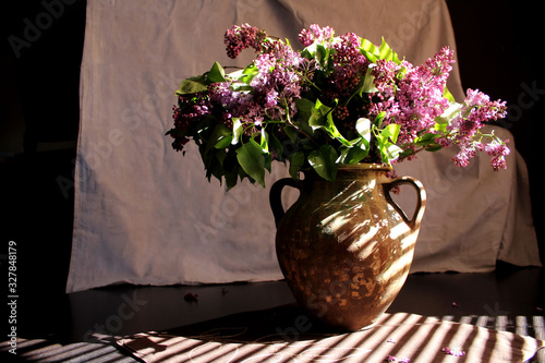 Fotografie lilacs and a cup on the table