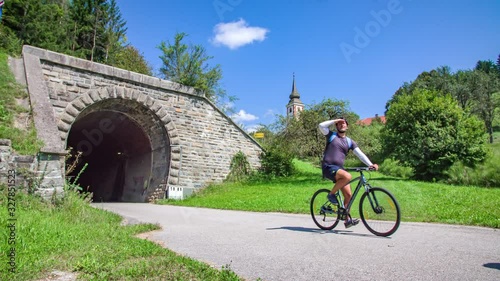 Medium Wide angle Shot of Four People Cycling their way out of Tunnel exit of Strekna Bicycle Path during the day time photo