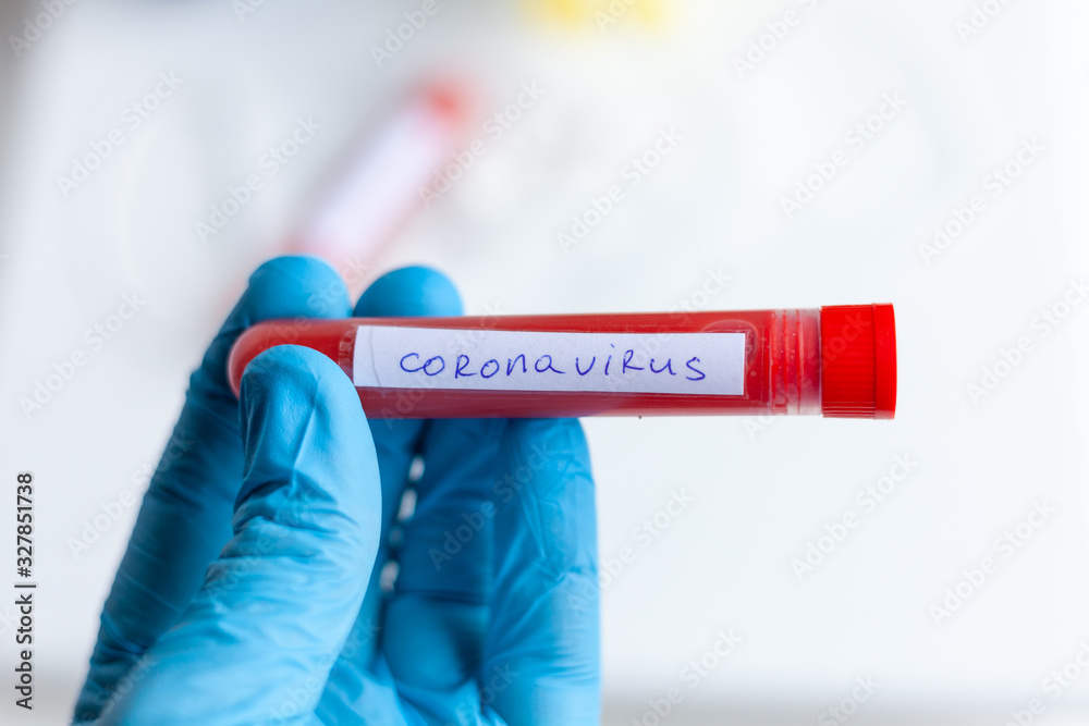 Obraz premium test tube in hand, inscription virus, coronavirus study, virus research