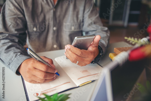Planner writing daily appointment On 2021 Calendar book. Asian man plan and noted schedule (holiday trip) on diary at office desk, work online at home. Calendar reminder for planner concept