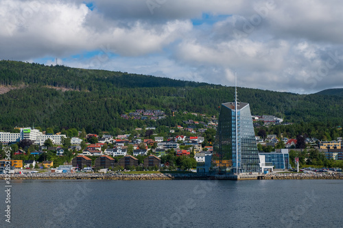 Molde, Norway - july 2019. Modern architecture on the background of Scandinavian mountains and blue sky. Sunny day in Molde, Norway. photo