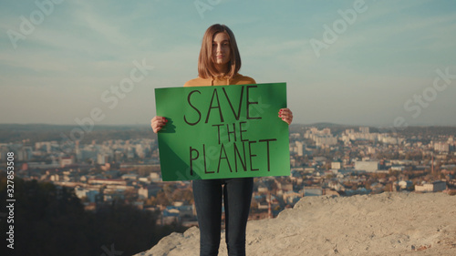 Shot of woman activist holding encouraging green poster Save the Planet standing background beautiful view nature environmental community earth eco environment outdoor recycle trash waste photo