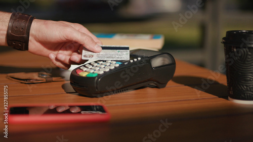 Young hands man payment with credit card in cafe customer hold phone finance money paying financial terminal transaction communication machine electronic shopping checkout slow motion