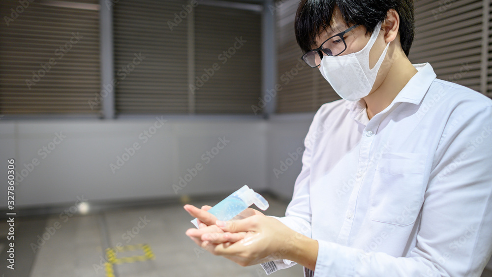 Φωτογραφία Asian man using hand skin sanitizer gel tube for washing hand at subway station