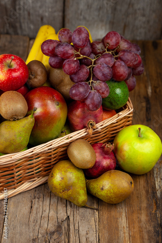 Different fruits in a basket. A large set of vitamin fruits. Healthy diet food. Vegan Food. Apples, bananas, pears, kiwi, grapes, pomegranate, avocado.