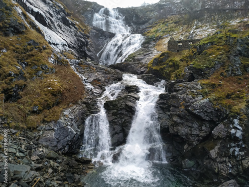 Large waterfall and dark mossy rocks. Kjosfossen, Norway photo