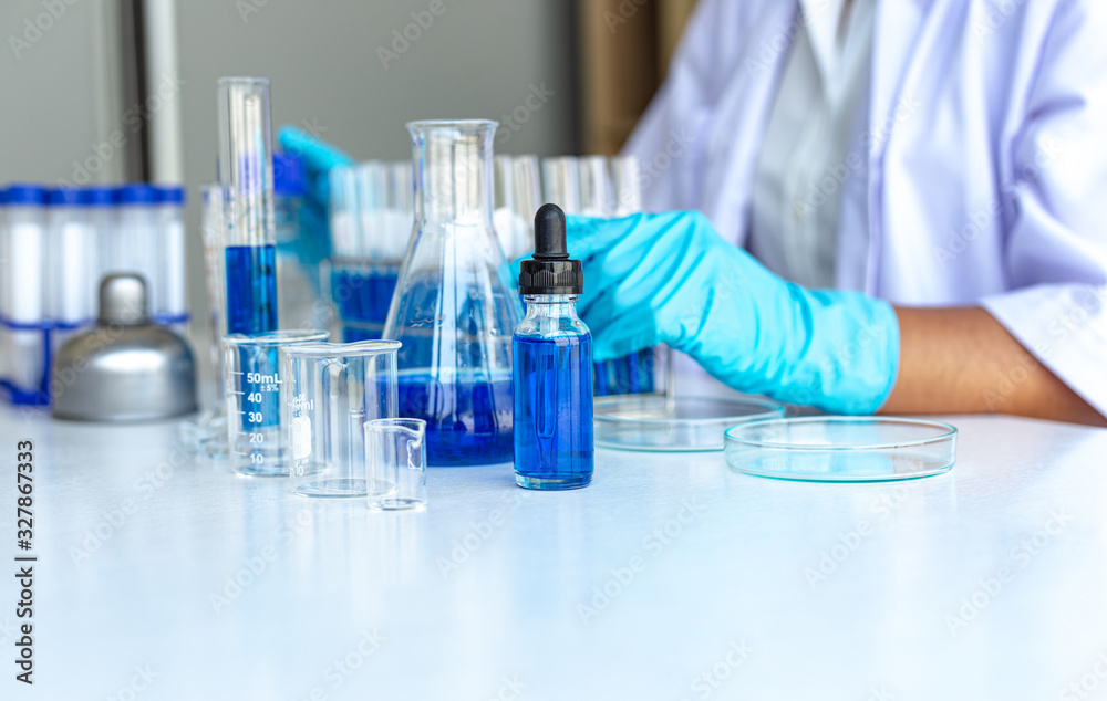 Fototapeta premium Scientists are carrying blue chemical test tubes to prepare for the determination of chemical composition and biological mass in a scientific laboratory, Scientists and research in the lab Concept.