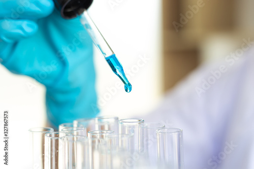 Scientists are carrying blue chemical test tubes to prepare for the determination of chemical composition and biological mass in a scientific laboratory, Scientists and research in the lab Concept.